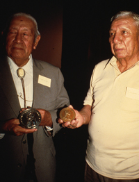 Two Quapaw men holding peace medals.