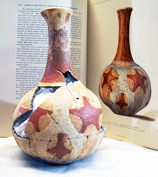 The reconstructed red and white painted Quapaw bottle in front of a book illustration of the same bottle.