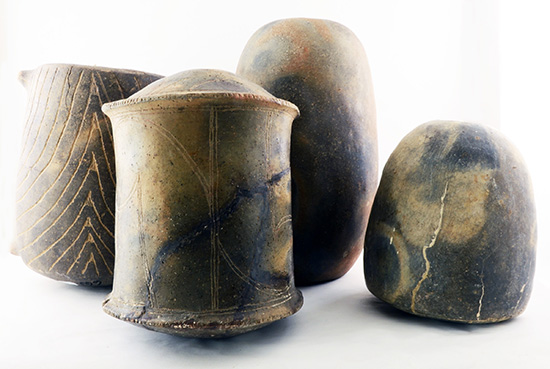 Four engraved pottery seed jars of varying sizes 