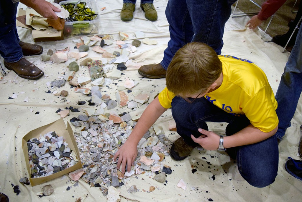 A Cub Scout from Pack 19 learns about flint knapping.