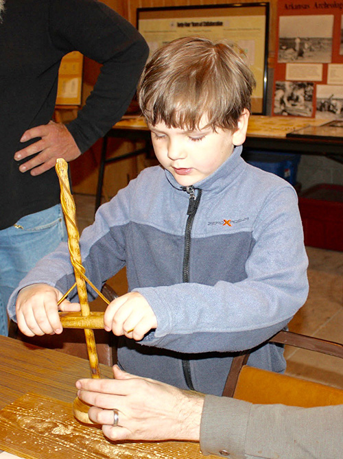 A local student tries his hand at using a replica drill