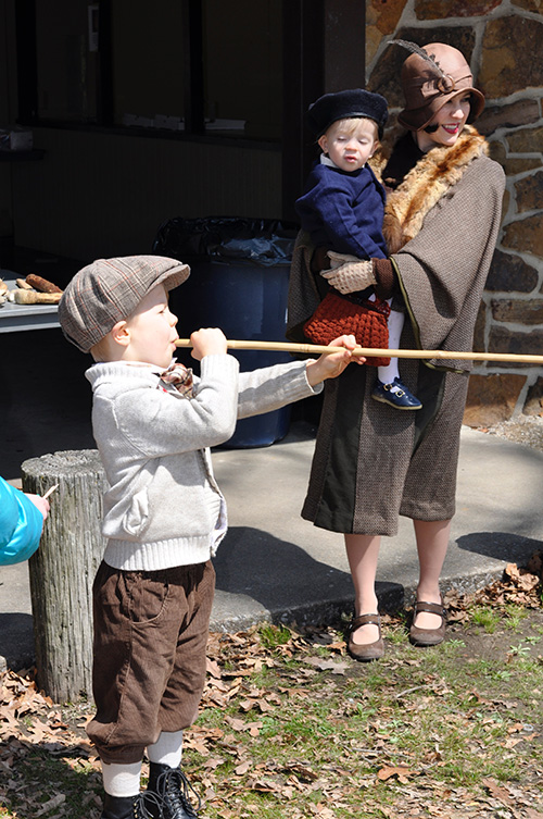 A young participant tests his skill with a blow gun during Archeology Day in Fayetteville.