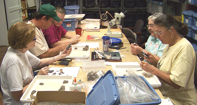 Florence Davis, Tony Caver, Vanessa Hanvey, Mary Ann Goodman, and Judy Thye analyze artifacts from 3HS60 (Hedges) in the HSU Research Station Archeology Lab in 2011.