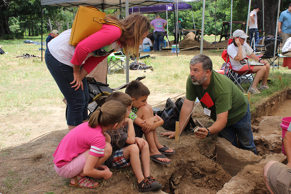 Society member Paul Knapp showing a piece of pottery to visitors during the Leetown site Open House.