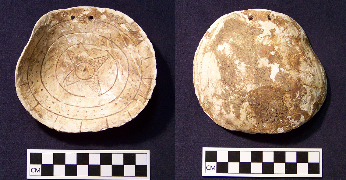 Figure 1. This engraved whelk shell gorget was found at the Shepherd site (3CL39) in Clark County, Arkansas. Drilled holes at the top indicate that it would have been worn as a necklace. 