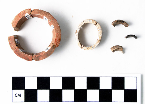 The Standridge earspools (left and center) were larger in diameter (41mm, 25mm) than three fragmentary earspools made from animal bone (right) from the Hughes site (15mm, 12mm, and 13mm estimated diameter). 