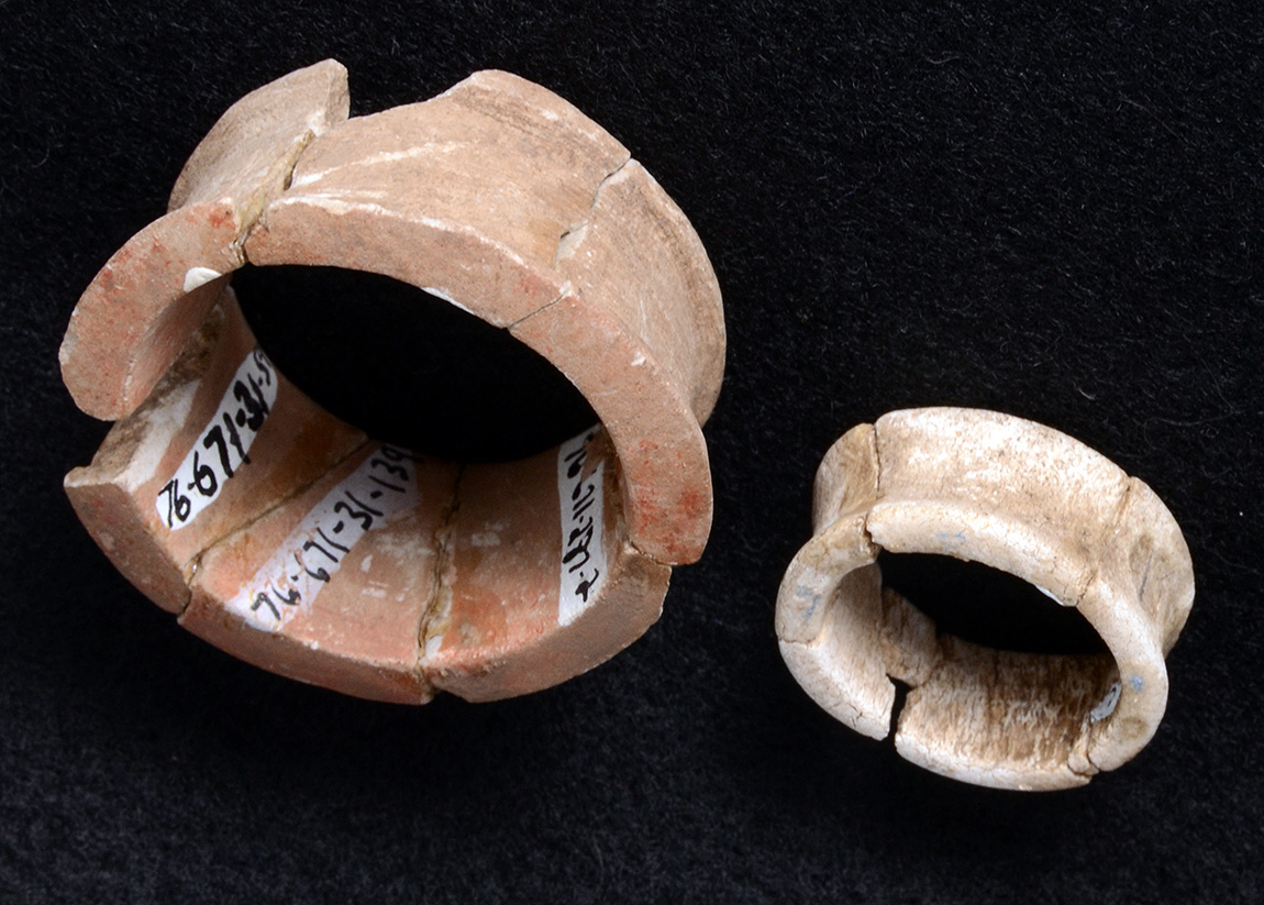 An earspool made from stone from the floor of structure Feature 12 at Standridge (left), with a smaller earspool made from animal bone from structure Feature 17 (right). 