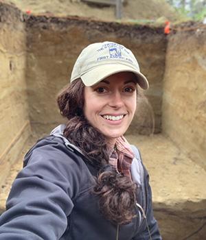 Photo of WRI station assistant Angela Gore standing in an excavated unit.