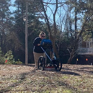 Photo of Taylor Green collecting data from a ground penetrating radar.