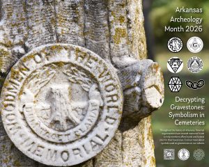 A moss-covered tombstone in the shape of a tree trunk.