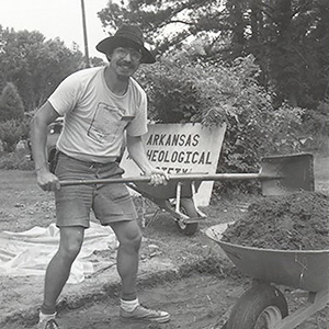 Black and white photo of Skip Stewart-Abernathy next to a wheelbarrow.